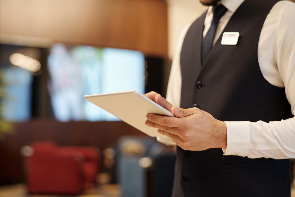 Closeup young male receptionist using tablet work